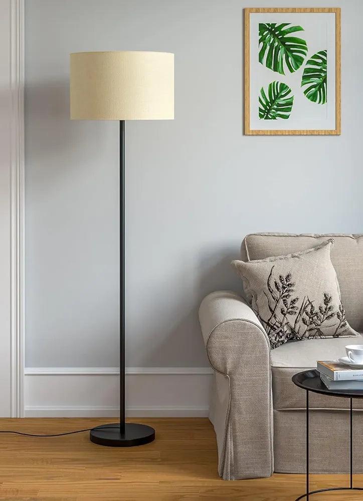 Elegant black floor lamp placed in a modern living home, lights off – minimalist design and round base