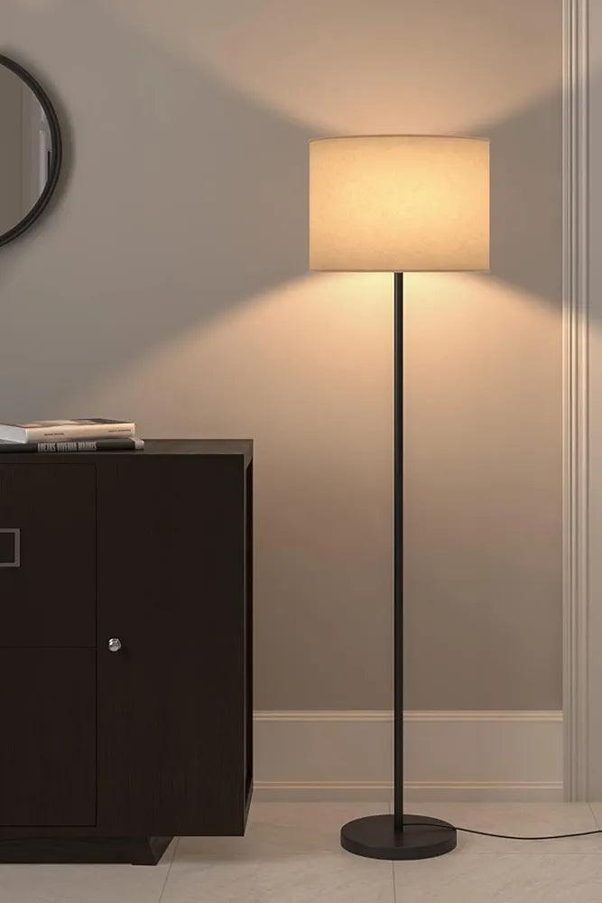 Full view of the standing black floor lamp in a cozy living room setting, switch on– perfect for modern interiors