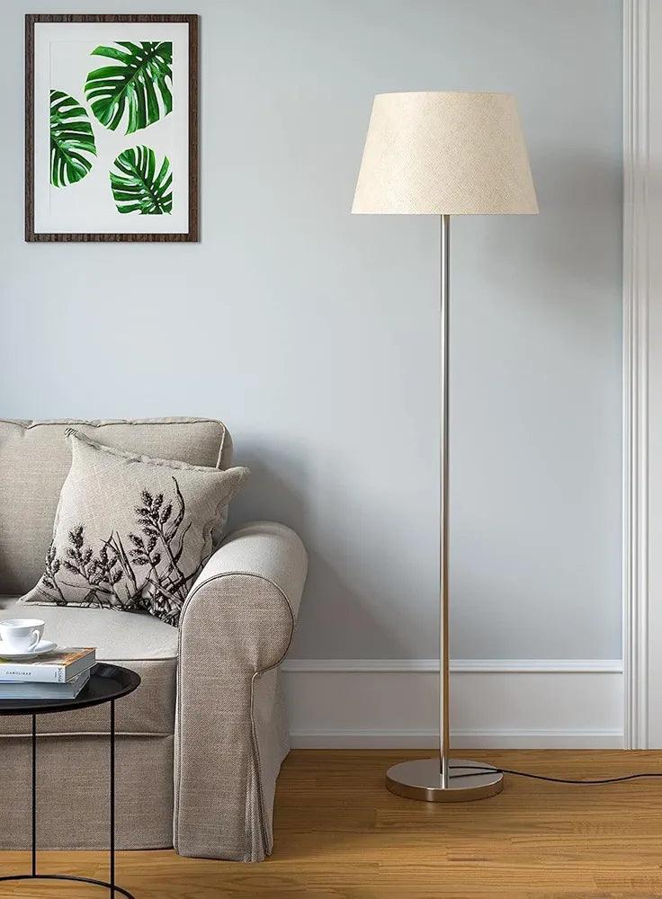 Stylish N I CREATIONS floor lamp with a cream shade, enhancing modern home decor near a cozy sofa