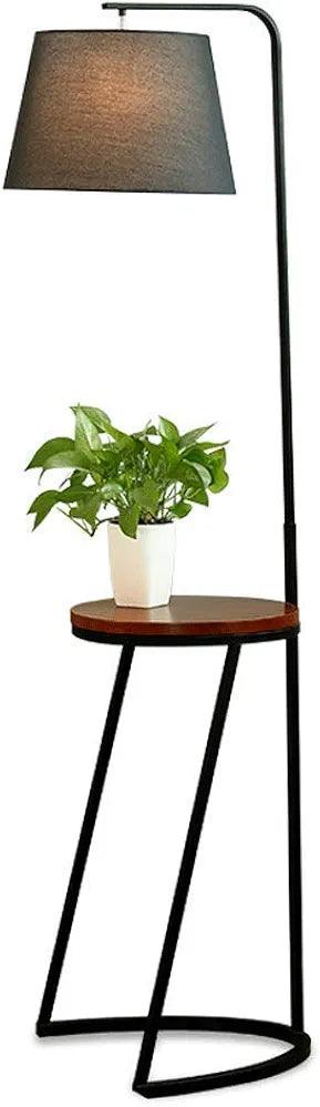 Stylish floor lamp with a round wooden table and a green plant for home decoration