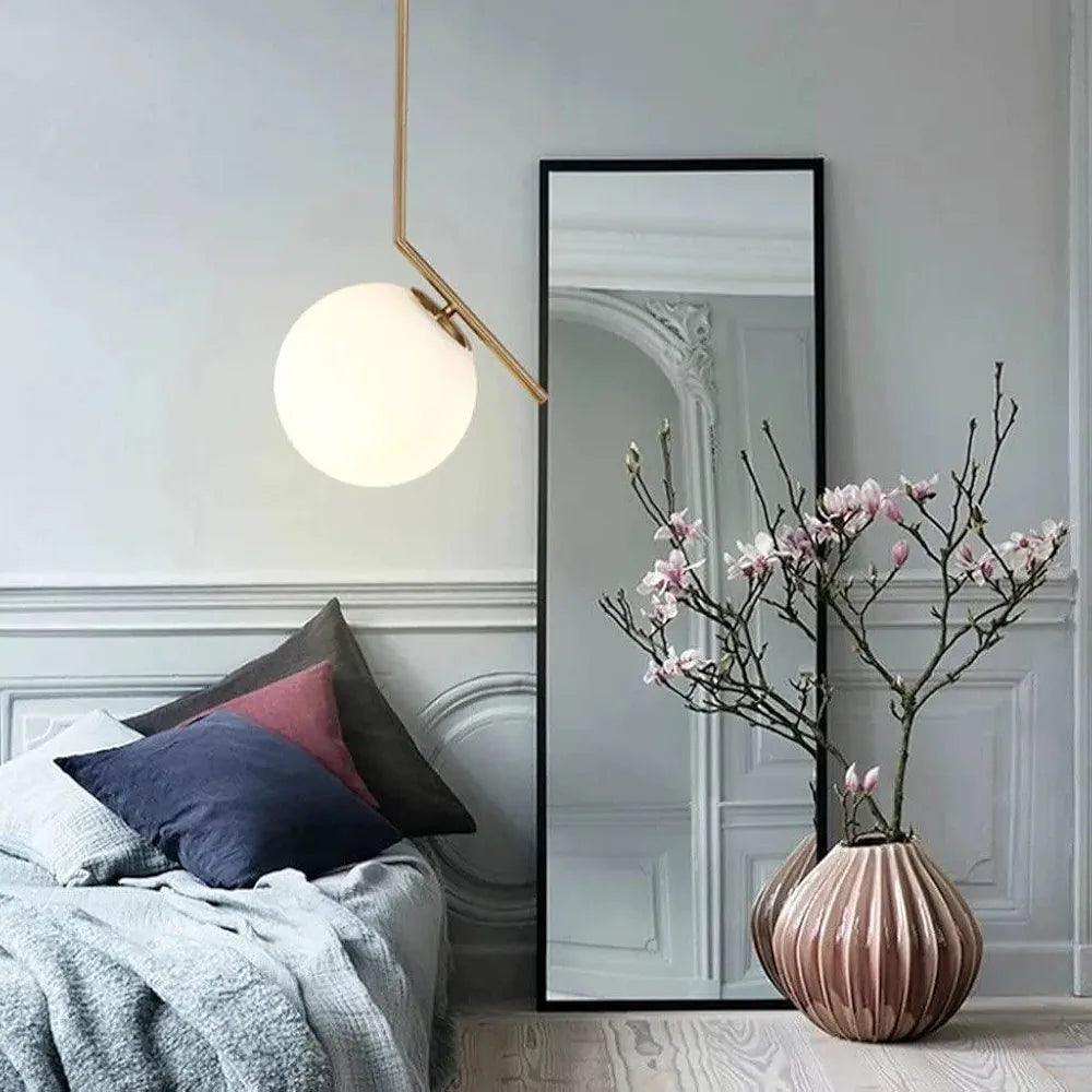 Stylish N I CREATIONS hanging lamp illuminating a cozy bedroom with decorative vase and mirror