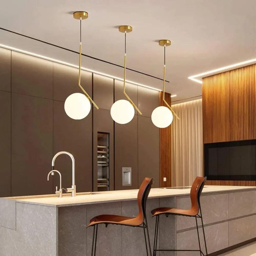 Modern N I CREATIONS hanging lamp trio above a kitchen island with sleek bar stools