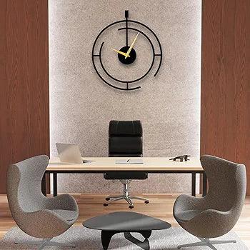 Stylish metal analog wall clock above a modern office desk with contemporary chairs