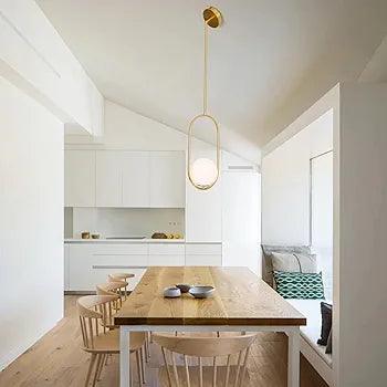 N I CREATIONS Pendant light in a modern dining area with wood table and stylish chairs