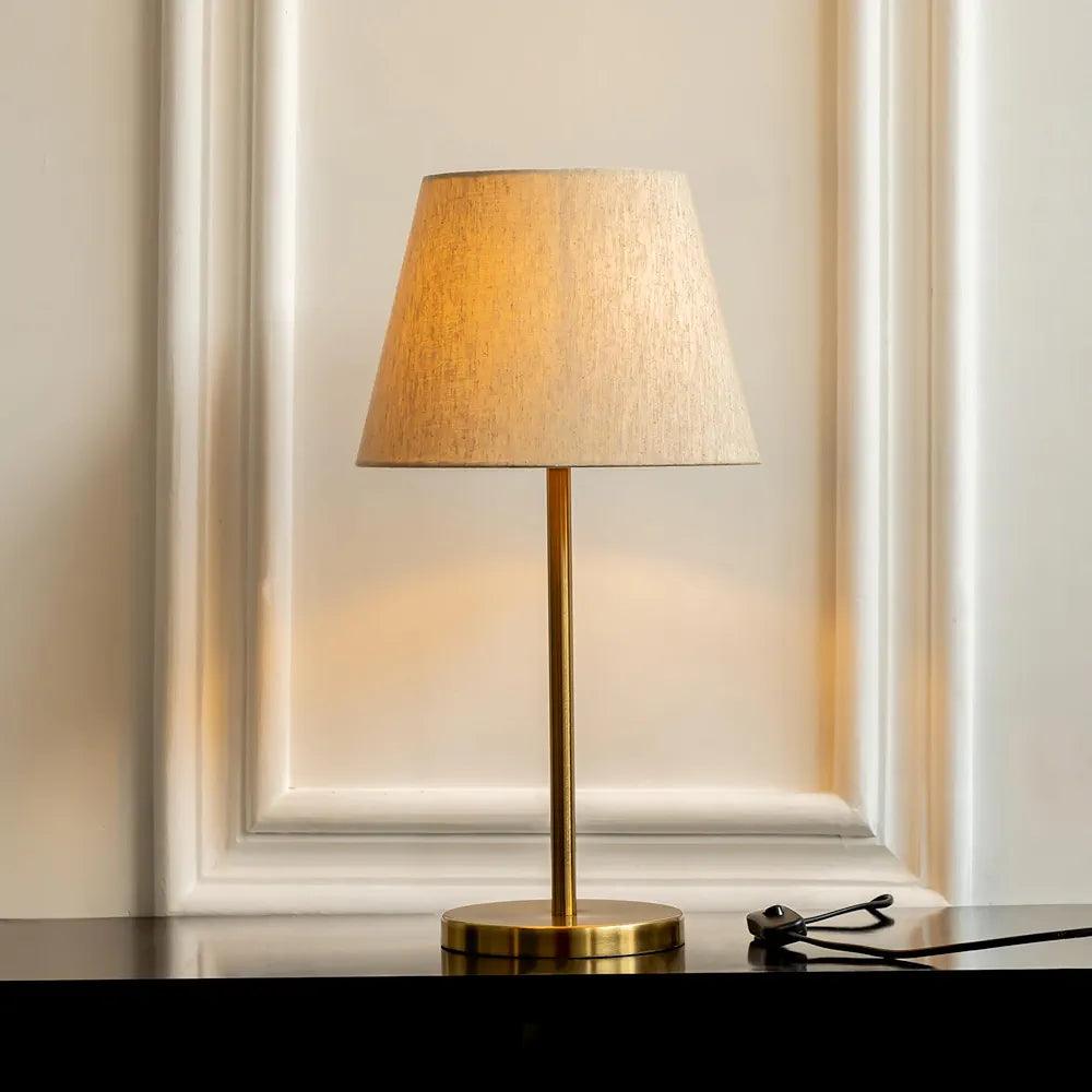 Elegant N I CREATIONS table lamp with a golden base and a soft fabric shade for home decor