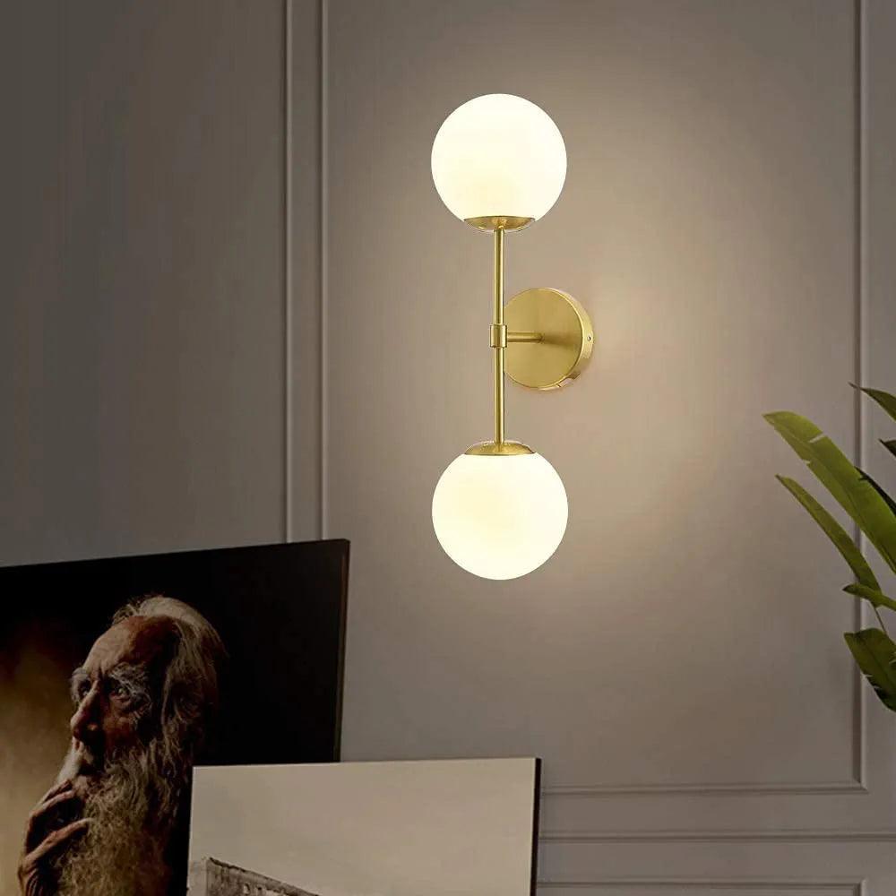 Modern N I CREATIONS wall lamp with two glass globes and a gold base for elegant home decor