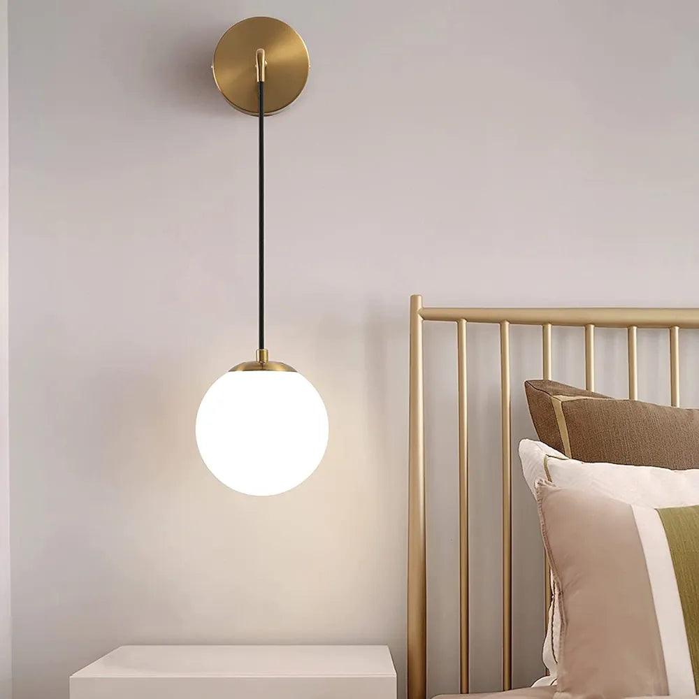 N I CREATIONS modern wall lamp with a round white glass shade and sleek brass fixture