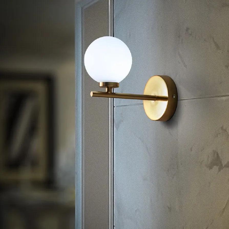 Elegant N I CREATIONS wall lamp with a round glass shade and gold finish, perfect for home decoration