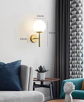 N I CREATIONS wall lamp with a gold base and a round glass shade, perfect for modern home decor