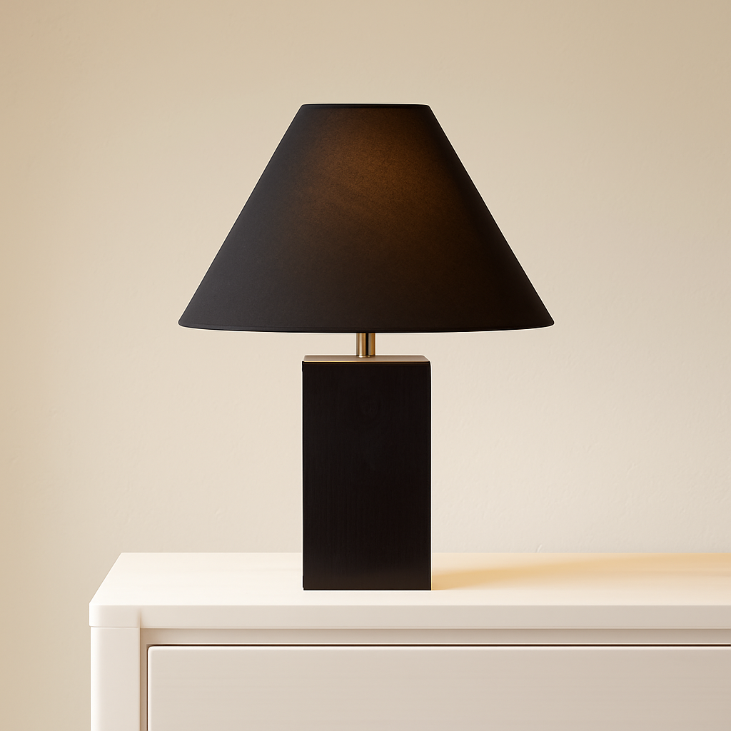 Black table lamp with a square base on a white surface against a beige wall