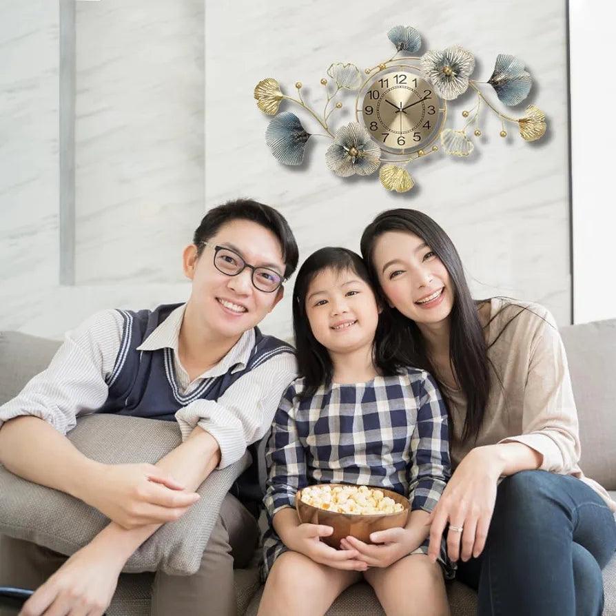 N I CREATIONS Floral wall clock elegantly displayed on the wall above a smiling family enjoying popcorn on a couch