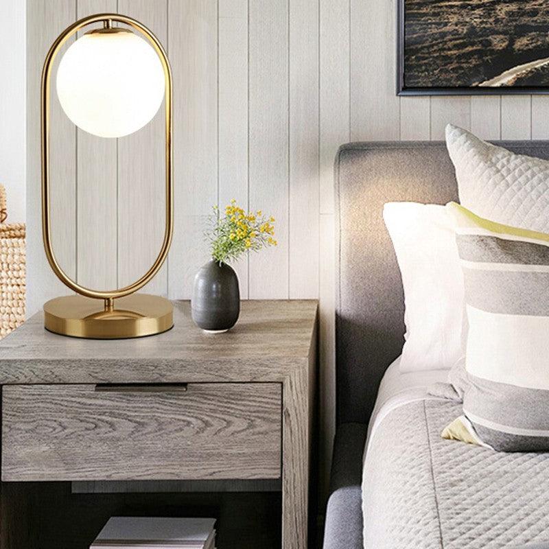 Modern N I CREATIONS night table lamp with a gold base and round glass shade for stylish home decoration