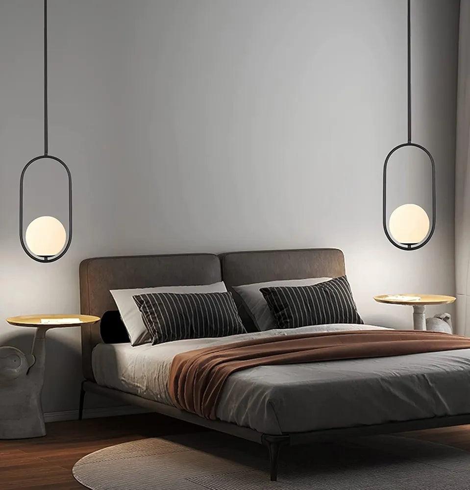 Modern pendant light featuring a round frosted shade above a stylish bedroom with a cozy bed