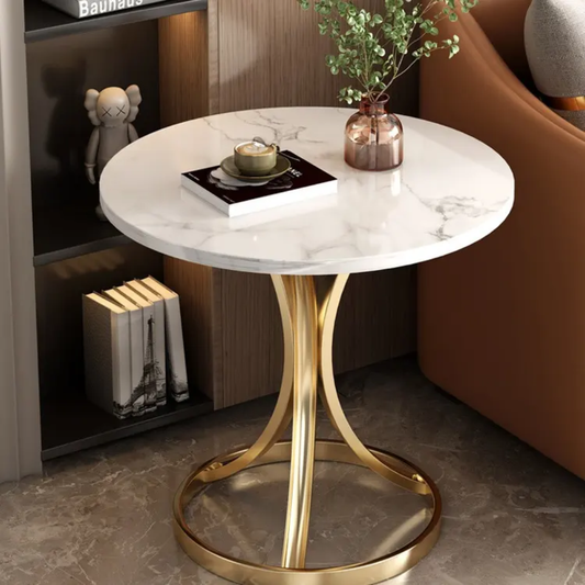 Round marble table with gold base in a room setting