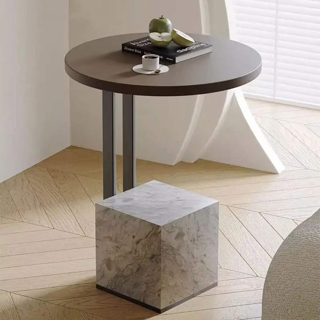 Round wooden table with a marble cube on a wooden floor