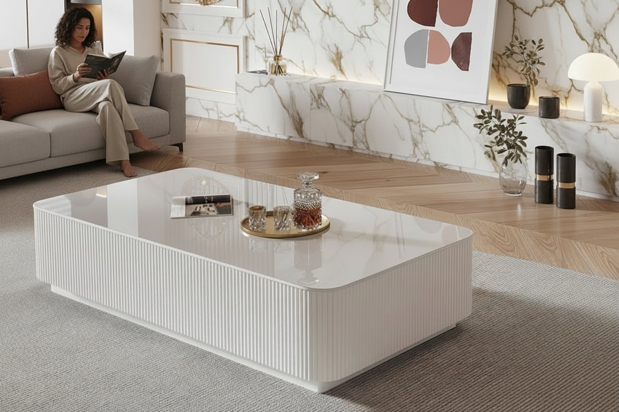 Modern white coffee table with decorative items in a living room setting