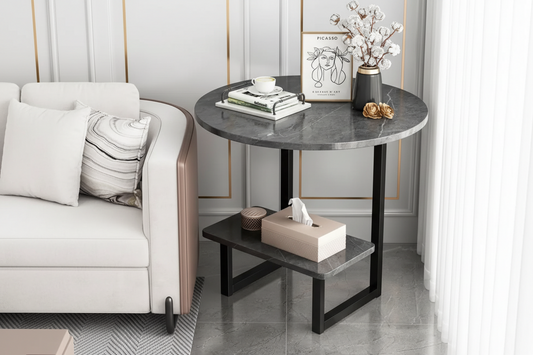 Round marble side table with black metal legs in a living room setting.
