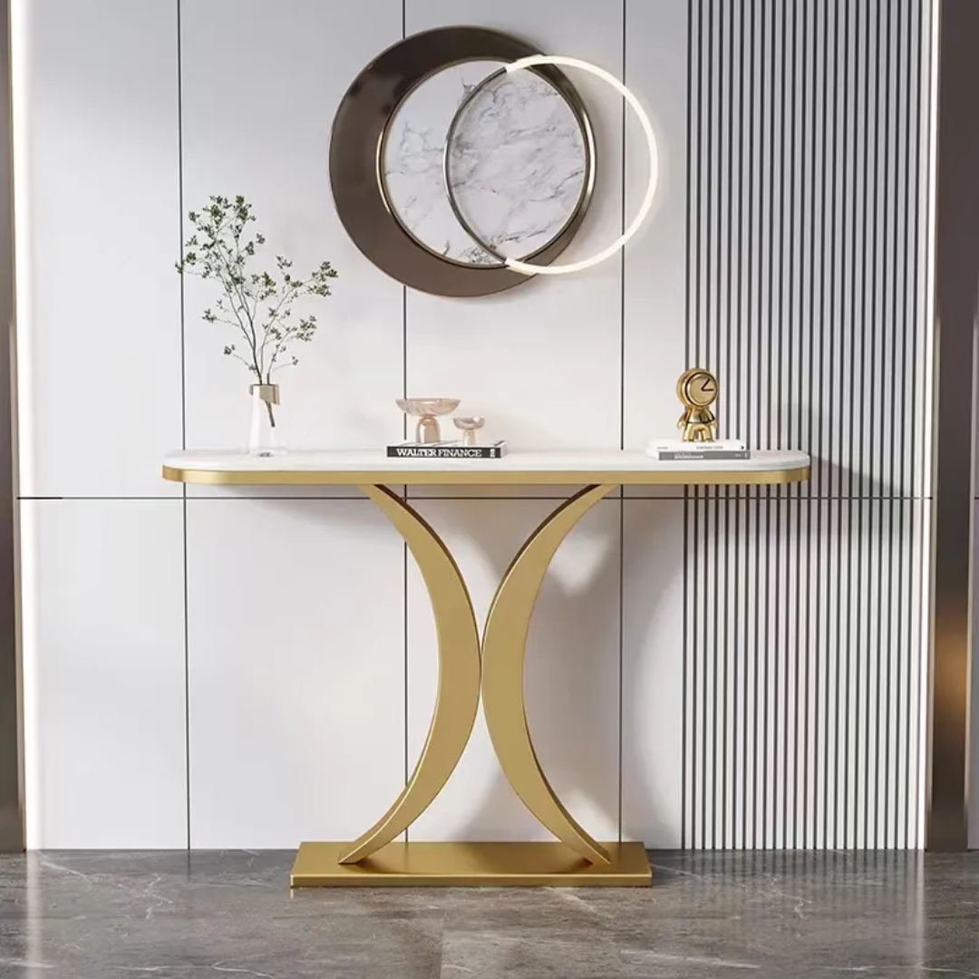 Modern console table with gold base and marble top against a striped wall.
