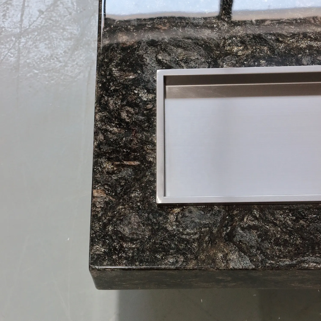Close-up of a dark granite countertop with a metallic frame.