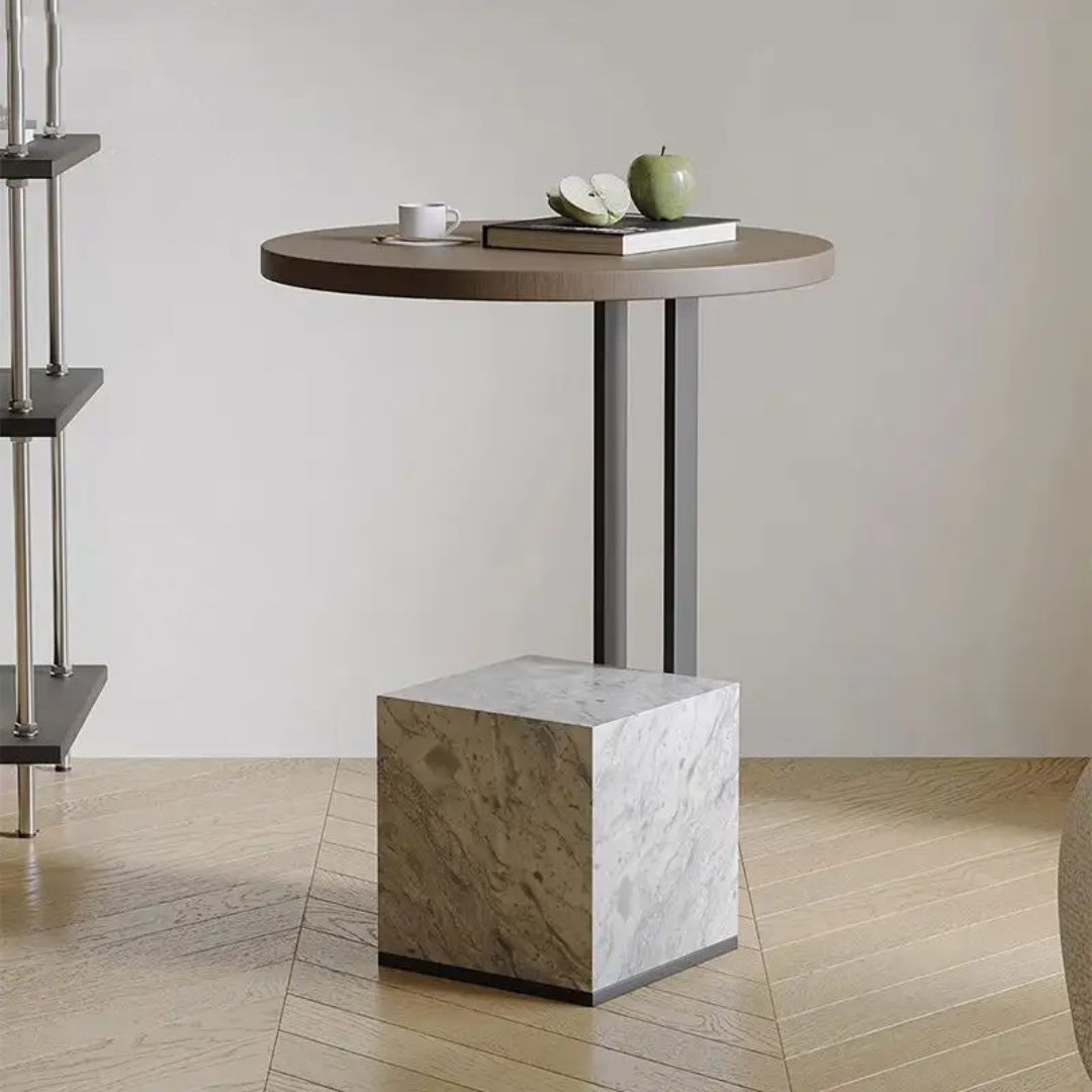 Small round wooden table with a marble cube base in a minimalistic setting