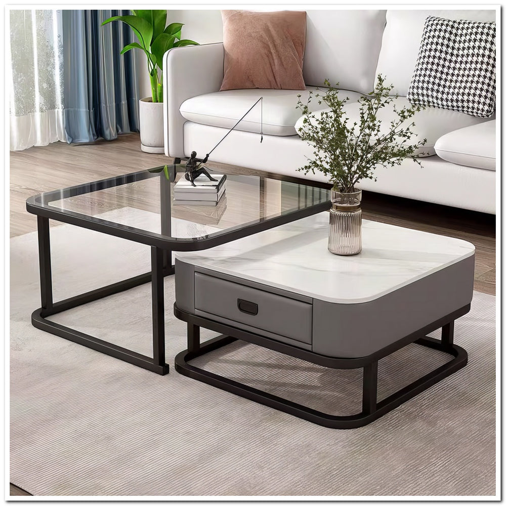 Modern coffee table set with glass top and gray base in a living room setting.