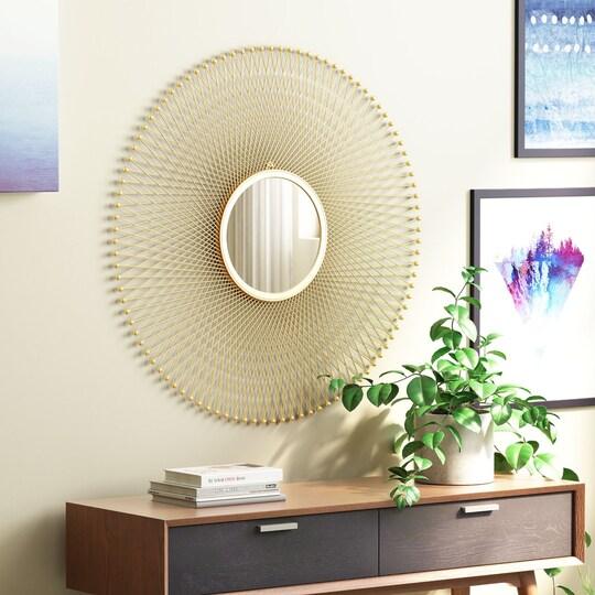 Round gold wall mirror mounted on white wall – clean full view